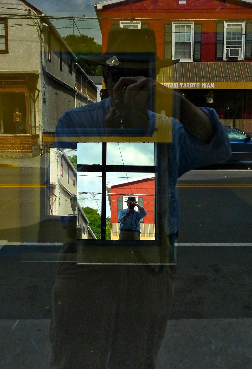 a reflection of the artist in a mirror in a store window - The spirit of Ren� Magritte visits Berryville - Berryville Virginia - Panasonic DMC-FZ28 - Tony Karp, design, art, photography, techno-impressionist, techno-impressionism, aerial photography , drone , drones , dji , mavic pro , video , 3D printing - Books -